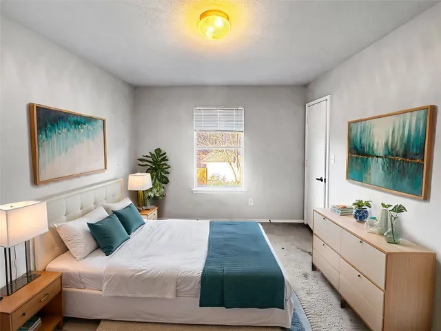 a bedroom with a bed mirror and window