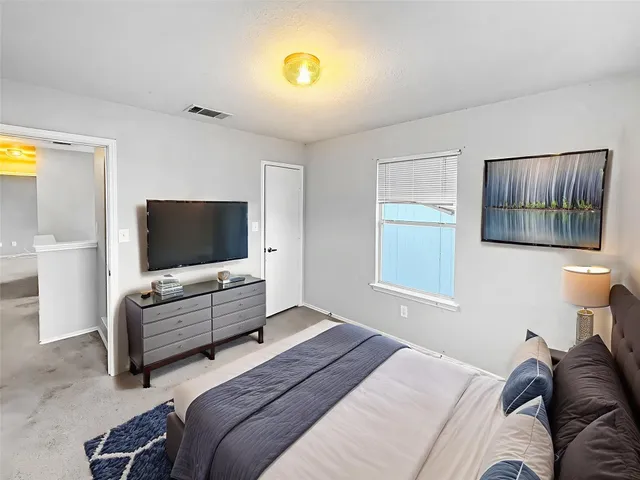 a bedroom with a bed and flat screen tv