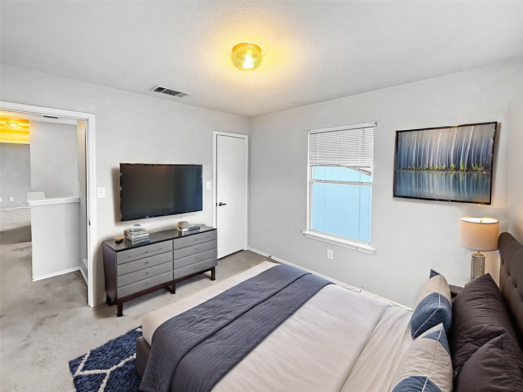 4516 Felicity Lane Austin, TX 78725 - Photo 4 of 15 a bedroom with a bed and flat screen tv