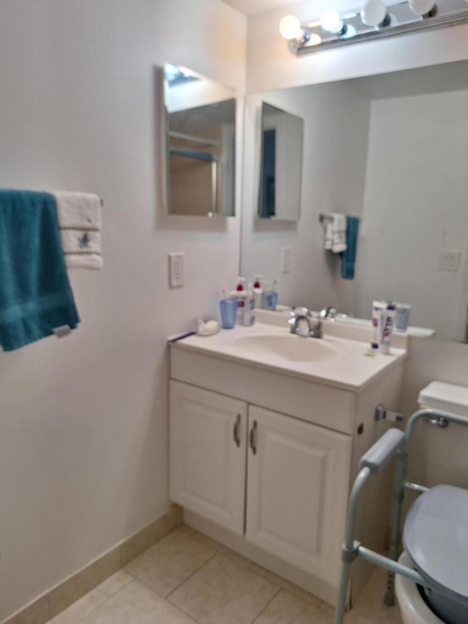 1010 Wolverton East Boca Raton, FL 33434 - Photo 9 of 30 a bathroom with a sink vanity and mirror