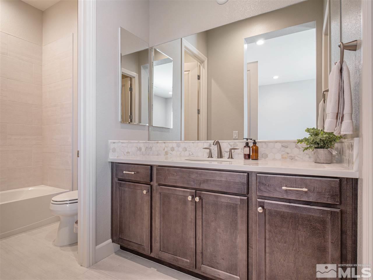 2224 Edgelands Drive Reno, NV 89521 - Photo 14 of 40 a bathroom with a granite countertop sink a toilet and a mirror