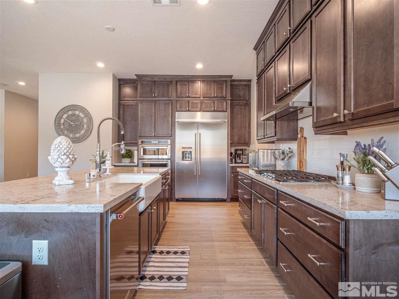 2224 Edgelands Drive Reno, NV 89521 - Photo 5 of 40 a kitchen with kitchen island granite countertop a sink stainless steel appliances and cabinets