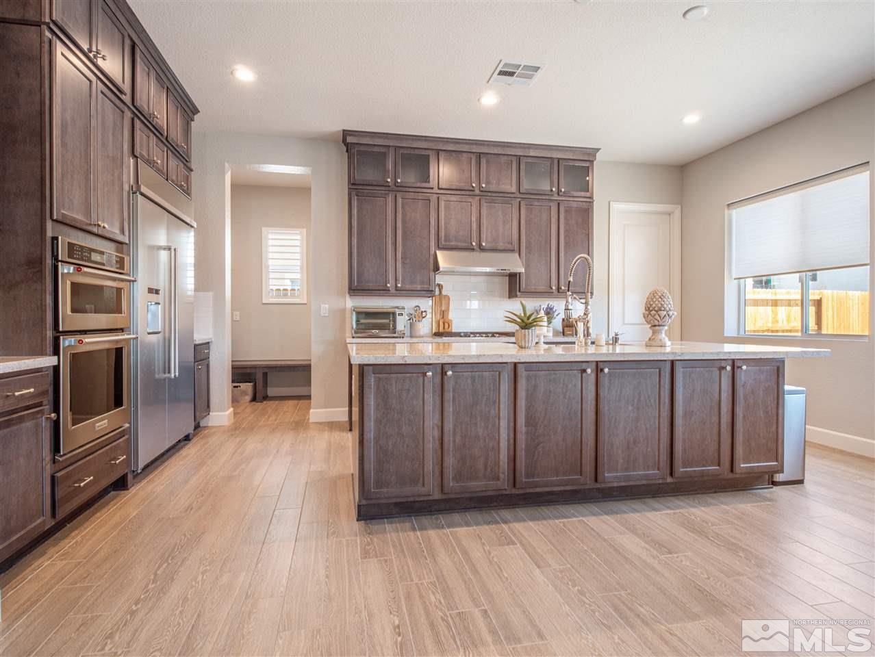 2224 Edgelands Drive Reno, NV 89521 - Photo 8 of 40 a kitchen with kitchen island granite countertop wooden floors stainless steel appliances a sink and a window
