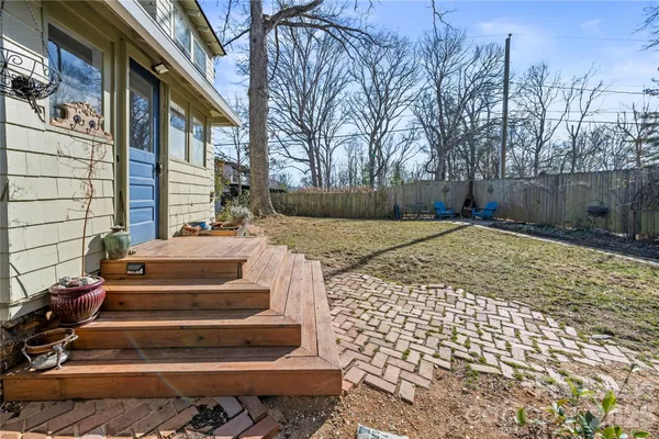 a view of backyard with wooden fence and trees