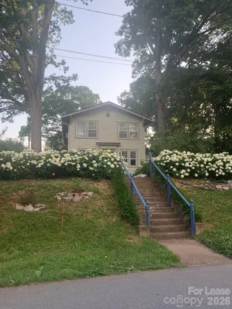 a view of a house with a yard next to a lake