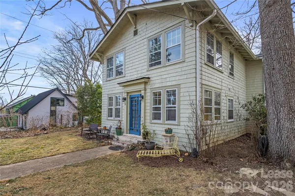 a view of a house with backyard and chairs