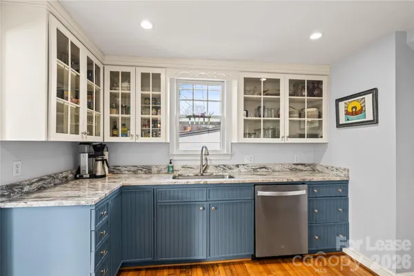 a kitchen with granite countertop a sink stove and cabinets