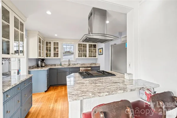 a kitchen with stainless steel appliances granite countertop a sink stove and cabinets