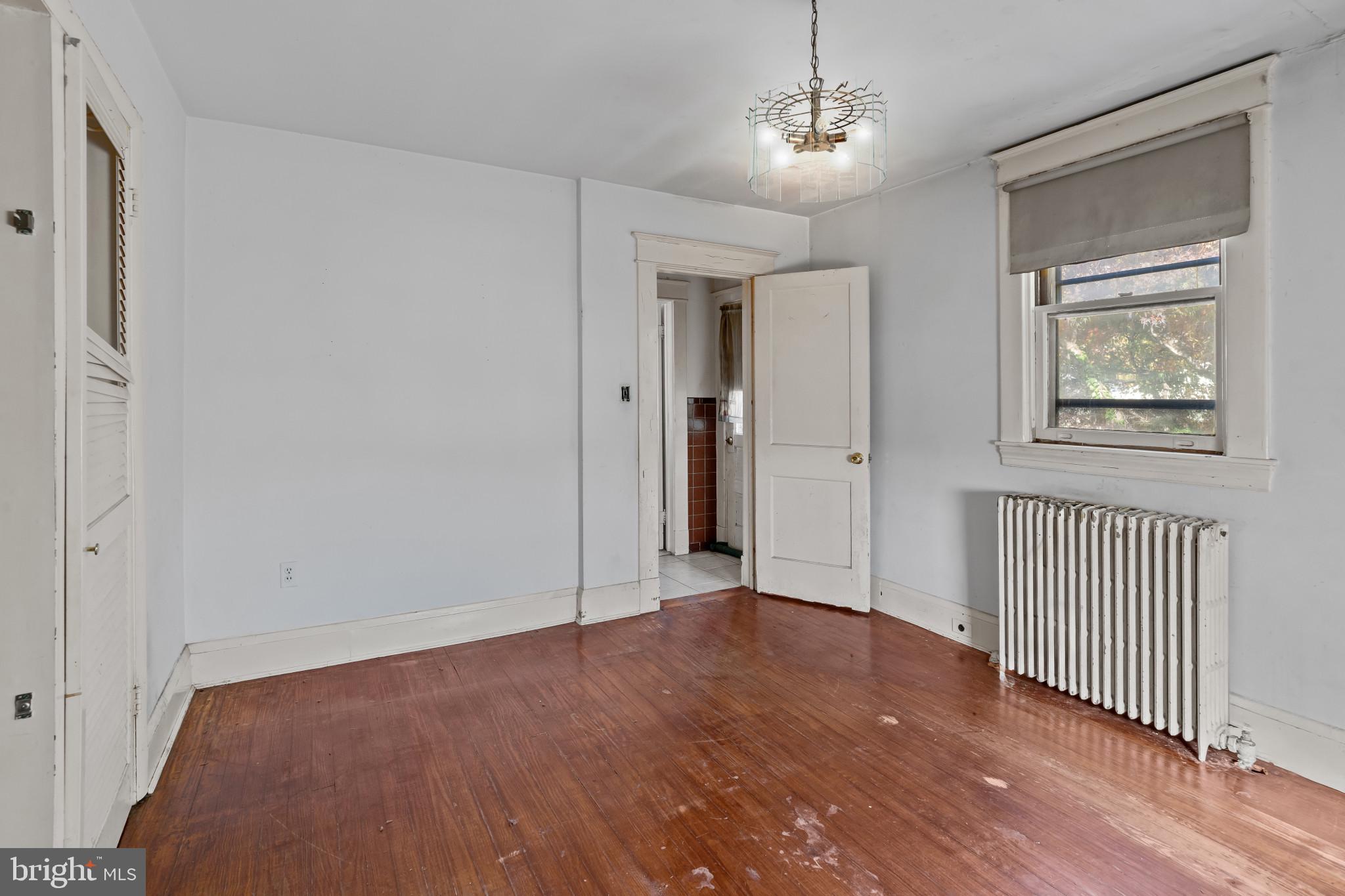 2908 Ailsa Avenue Baltimore, MD 21214 - Photo 14 of 29 an empty room with wooden floor chandelier and windows