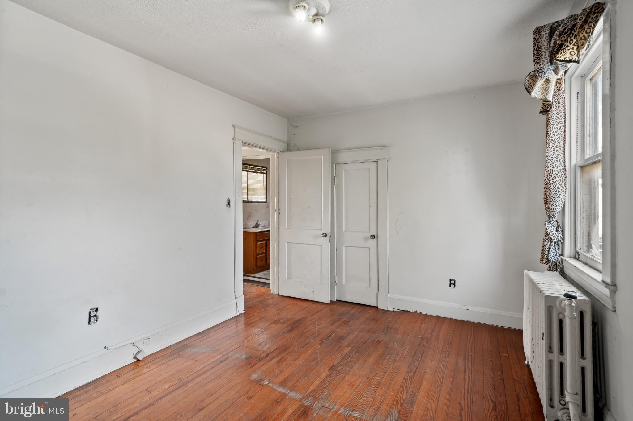 2908 Ailsa Avenue Baltimore, MD 21214 - Photo 23 of 29 a view of an empty room with wooden floor and a window