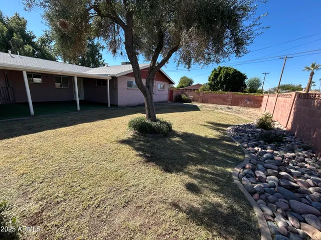 a view of a house with backyard and sitting area