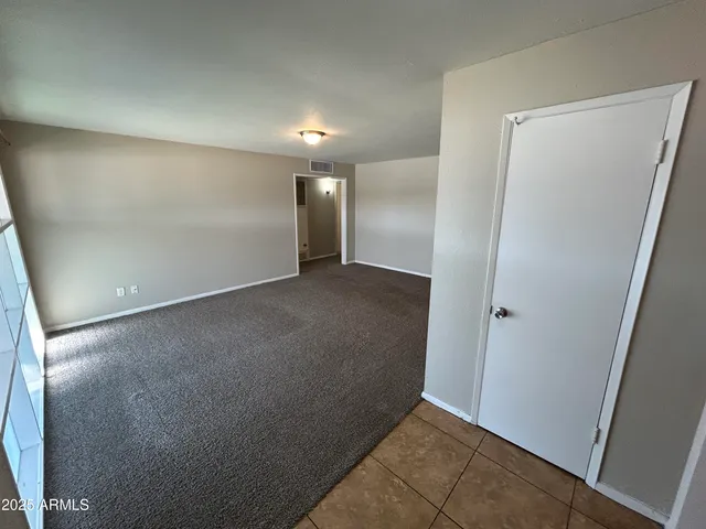 an empty room with wooden floor and mirror