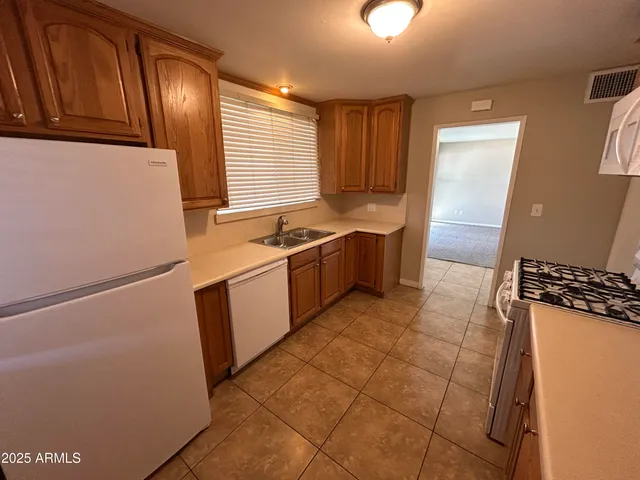 a kitchen with a sink a stove cabinets and a window