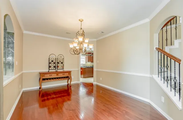 a view of a livingroom with wooden floor and stairs