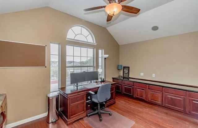 a view of a workspace with furniture and a window