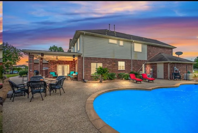 a view of a patio with table and chairs under an umbrella