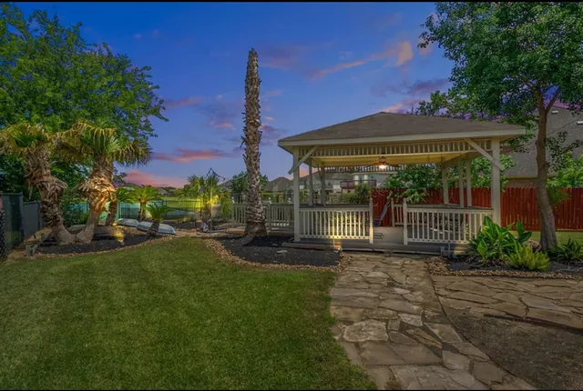 a view of a house with backyard and sitting area