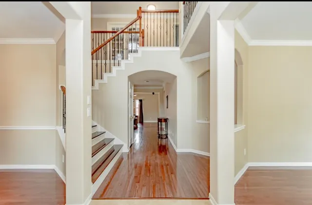 a view of a hallway with wooden floor and staircase