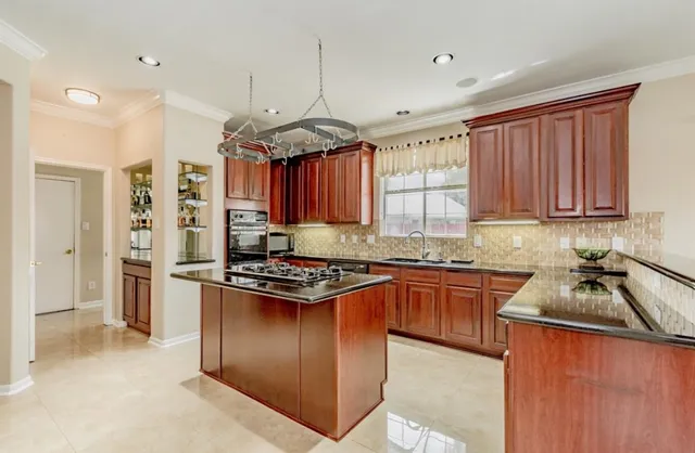 a kitchen with stainless steel appliances granite countertop a stove top oven a refrigerator a sink and dishwasher