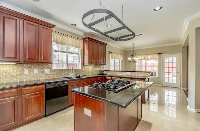 a kitchen with stainless steel appliances granite countertop a stove sink and cabinets