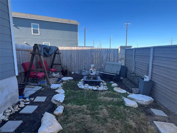 a view of a backyard with plants and chairs