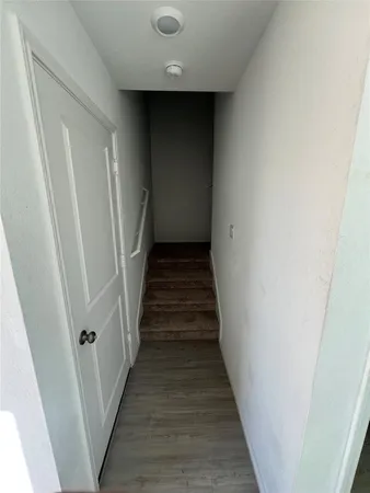 a view of staircase with wooden floor and white walls