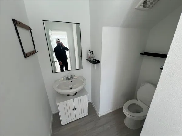 a bathroom with a toilet a sink and mirror