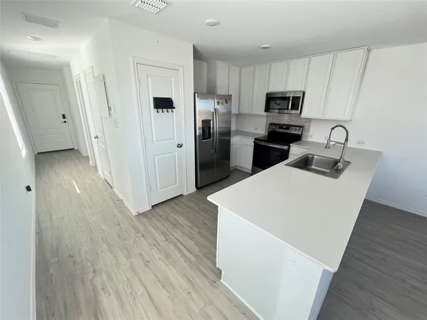 a kitchen with white cabinets and stainless steel appliances