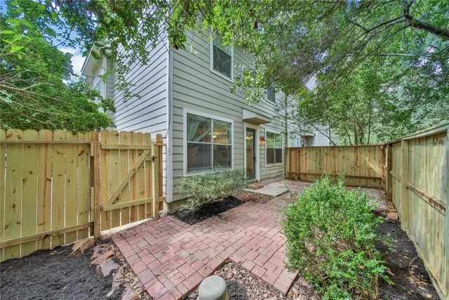 a view of a backyard with potted plants and a large tree