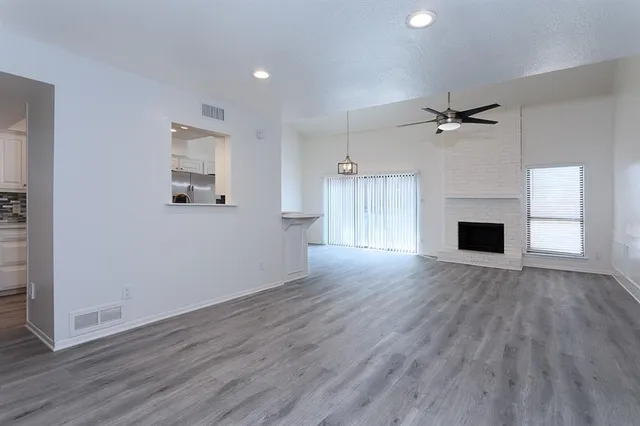 a view of empty room with a fireplace and wooden floor