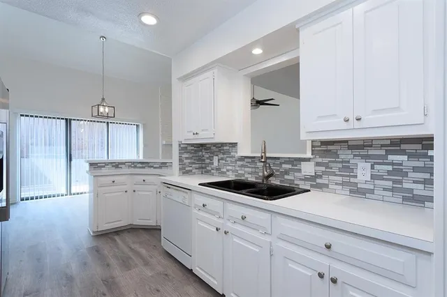 a kitchen with white cabinets and stainless steel appliances