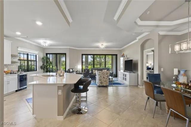 a living room with furniture a large window and kitchen view