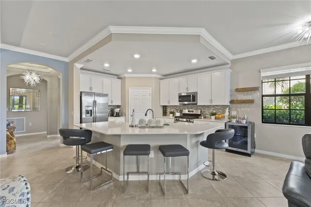 a kitchen with a dining table chairs refrigerator and cabinets