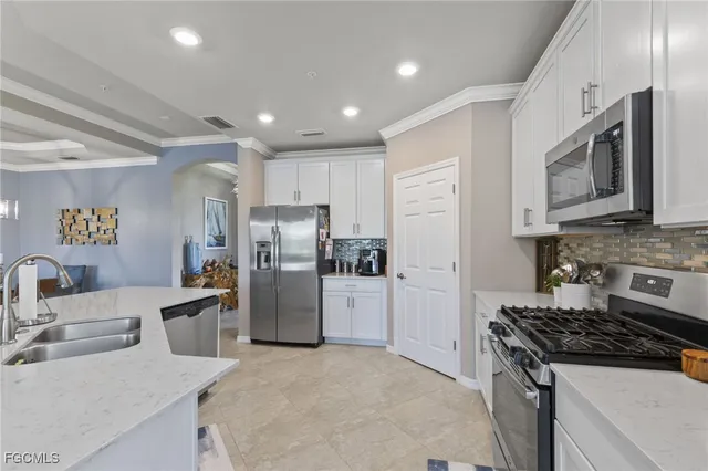a kitchen with refrigerator a microwave a stove and cabinets