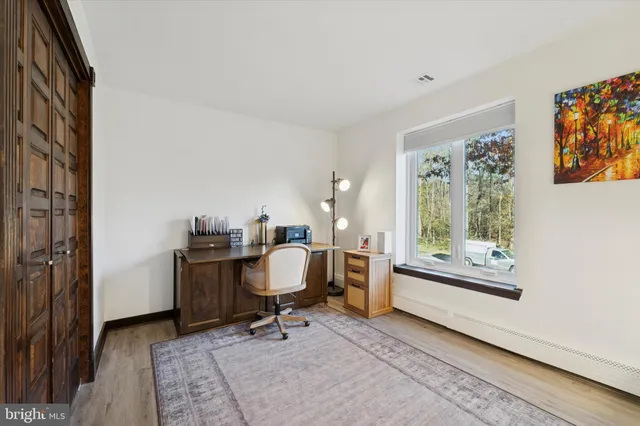 a view of a workspace with furniture and a window