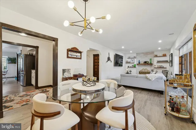 a living room with furniture and a dining table with wooden floor
