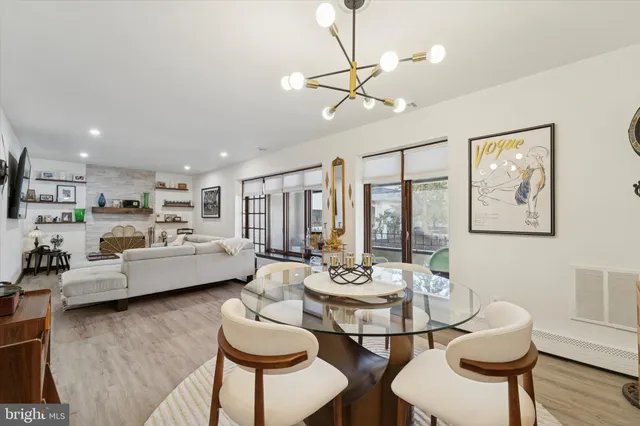 a living room with furniture kitchen view and a large window
