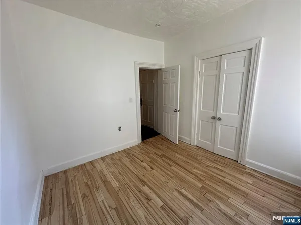 a view of a room with wooden floor and closet