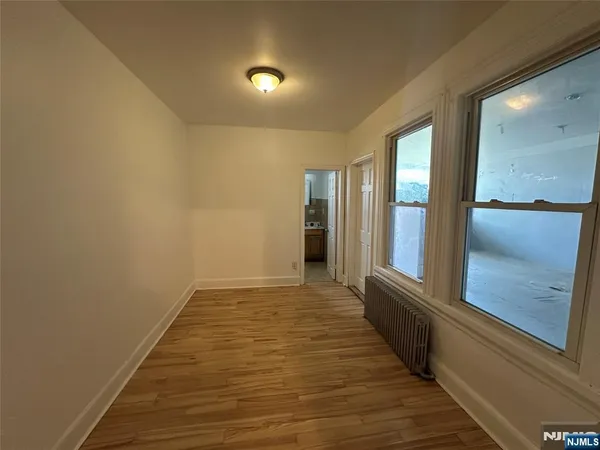 a view of a room with wooden floor and windows