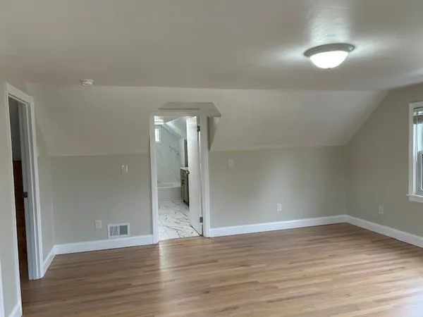 a view of empty room with wooden floor