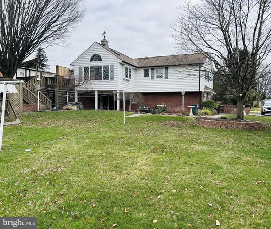 a front view of a house with a garden and trees