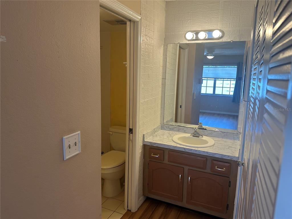 2250 Druid Road, Unit 403 Clearwater, FL 33764 - Photo 13 of 17 a bathroom with a granite countertop sink a toilet and a mirror