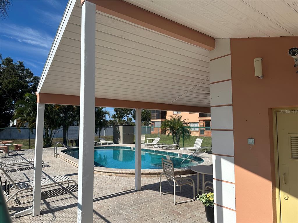 2250 Druid Road, Unit 403 Clearwater, FL 33764 - Photo 17 of 17 a patio with table and chairs and potted plants