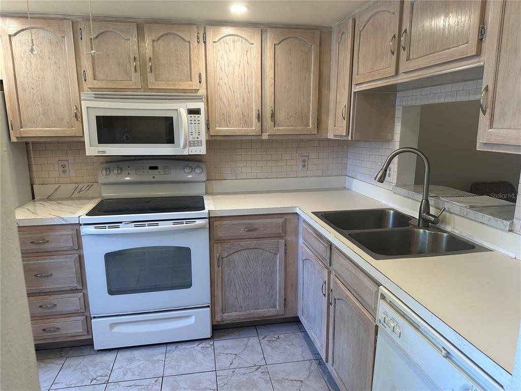 2250 Druid Road, Unit 403 Clearwater, FL 33764 - Photo 4 of 17 a kitchen with cabinets stainless steel appliances and a sink