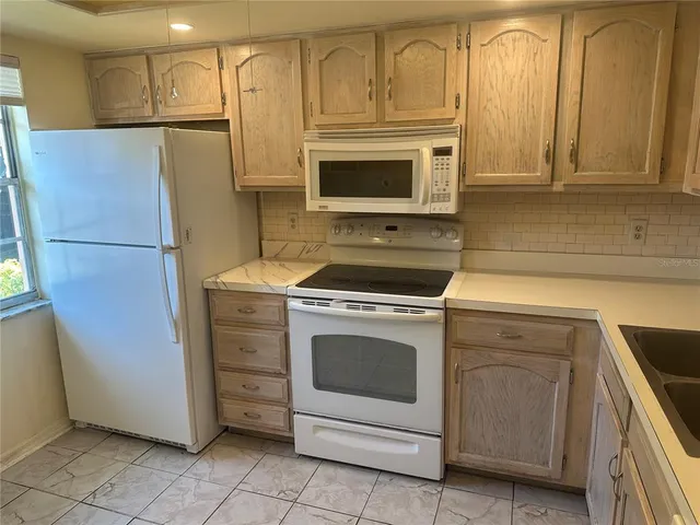 a kitchen with white cabinets and white appliances
