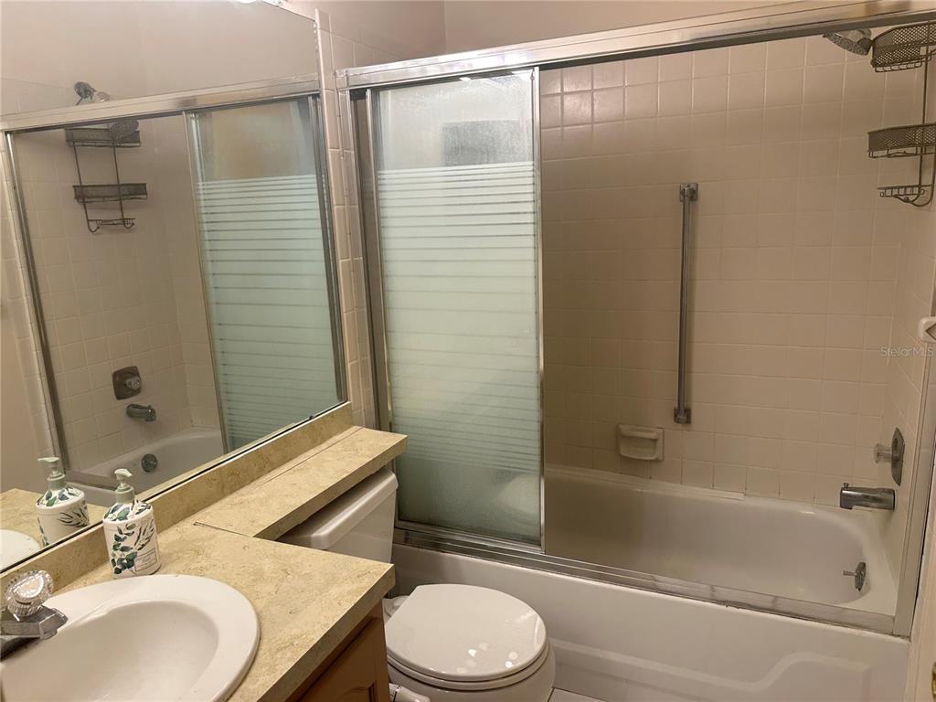 2250 Druid Road, Unit 403 Clearwater, FL 33764 - Photo 9 of 17 a bathroom with a granite countertop sink toilet and shower