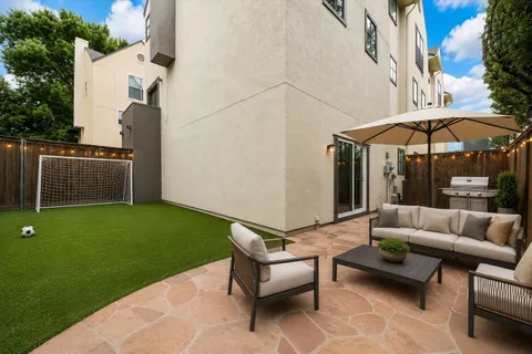 a backyard of a house with table and sofas