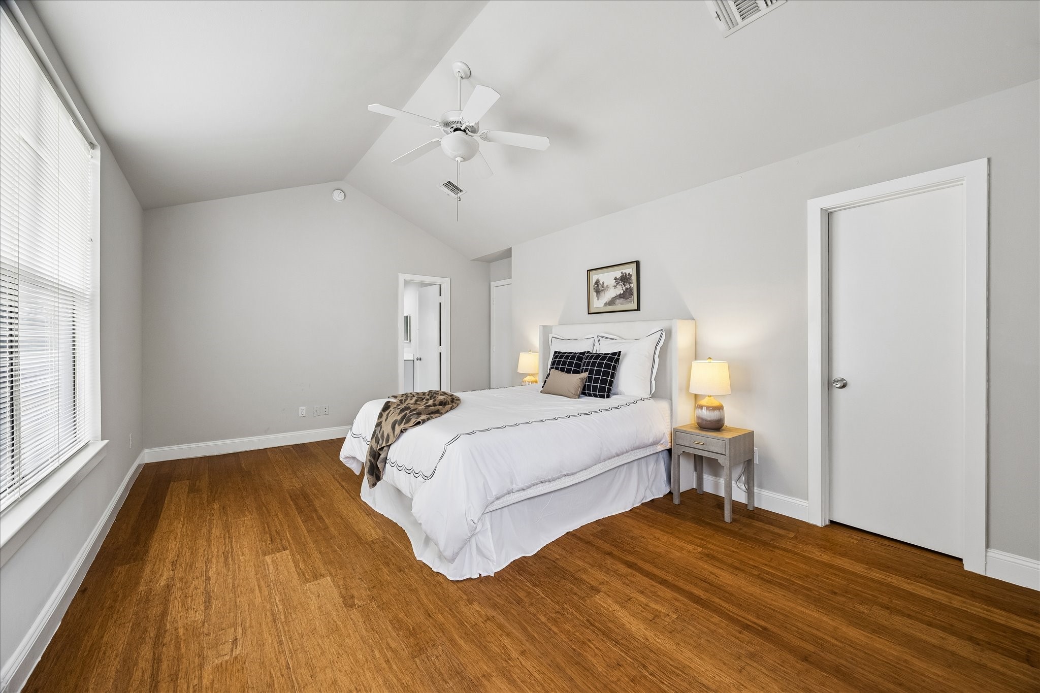 939 Colorado Street, Unit 22 Houston, TX 77007 - Photo 13 of 23 a bedroom with a bed and wooden floor