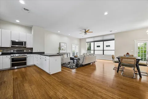 a kitchen with stainless steel appliances granite countertop a stove a sink and white cabinets