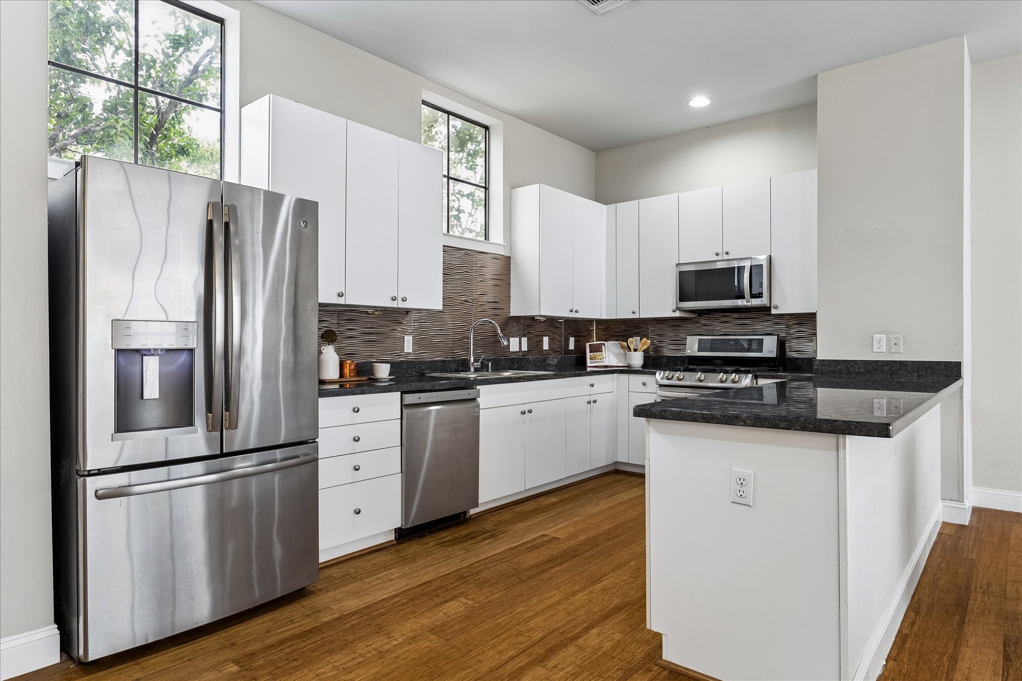 939 Colorado Street, Unit 22 Houston, TX 77007 - Photo 6 of 23 a kitchen with granite countertop a refrigerator stove and microwave